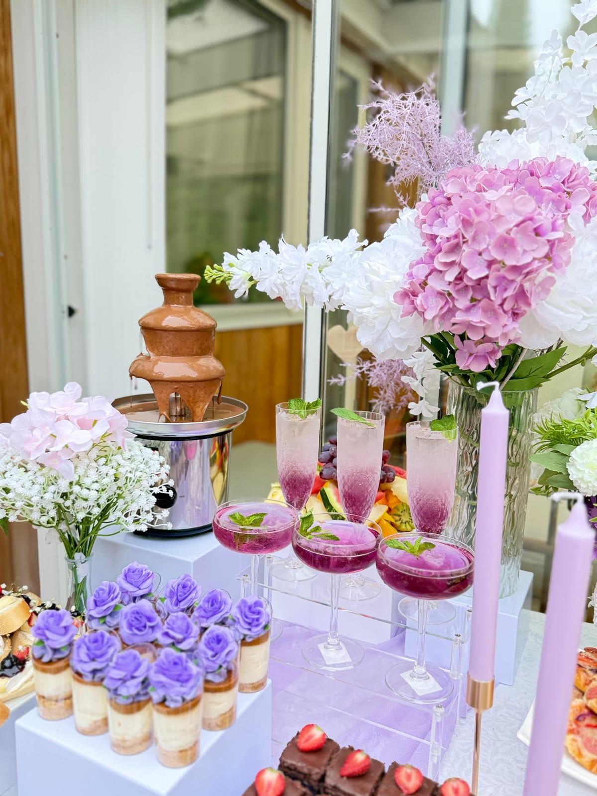 Chokladfontän och glasdesserter omgivna av hortensior