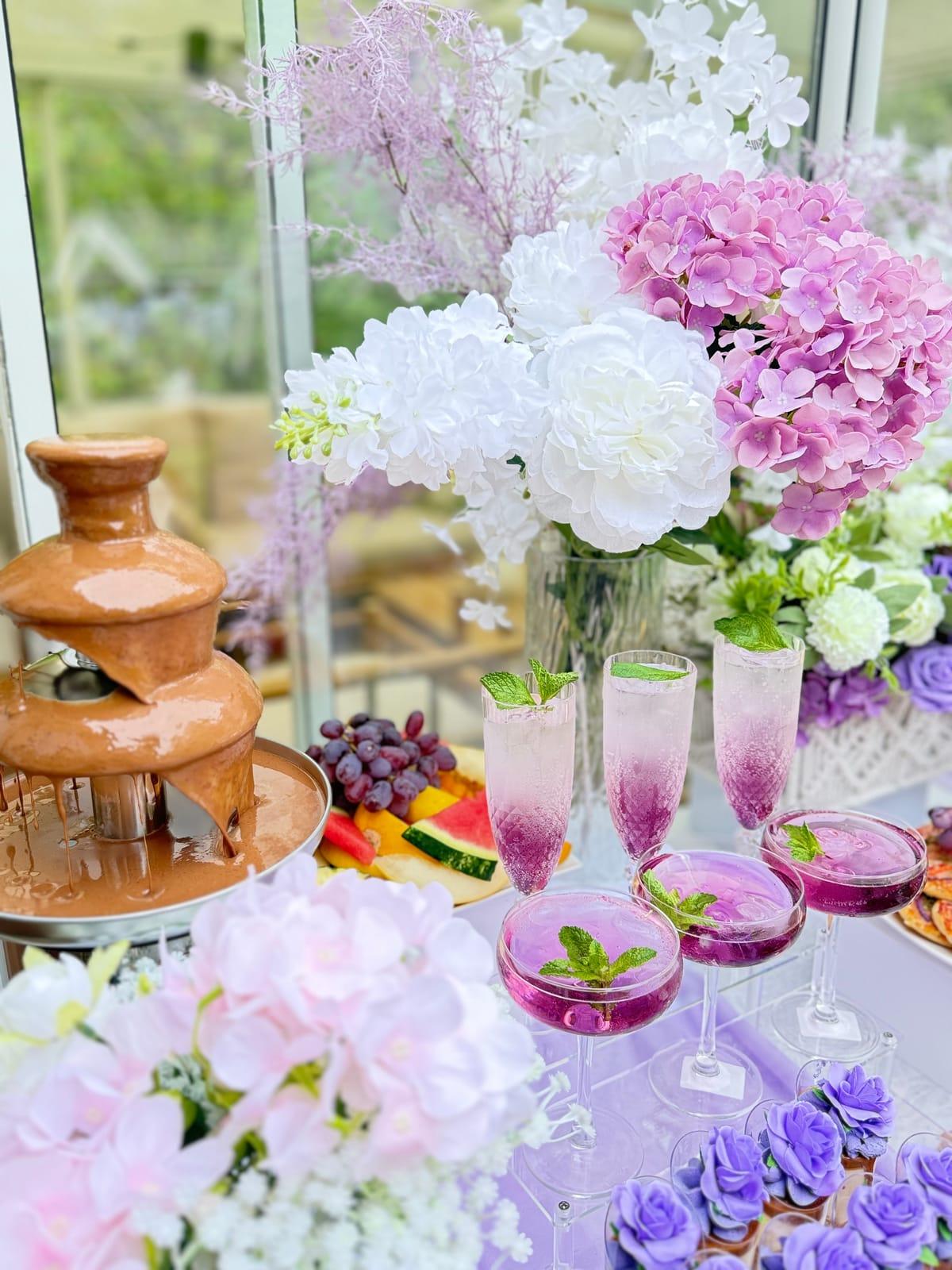Chokladfontän med druvor och rosa mocktails