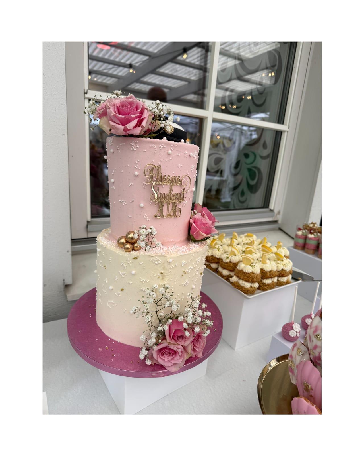 Rosa festtårta i två våningar på dessertbord