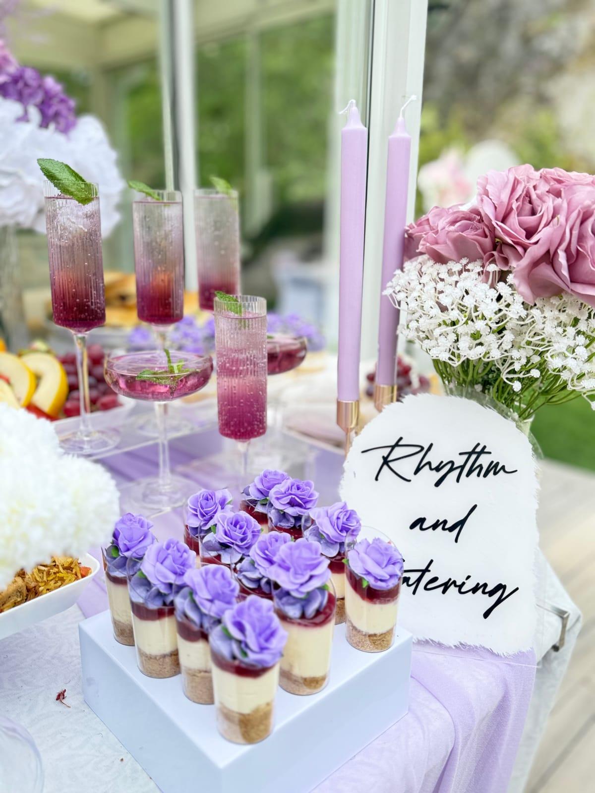 Rhythm and Catering dessertbord i lila: cheesecake i glas med sockerrosor, mocktails och blommor