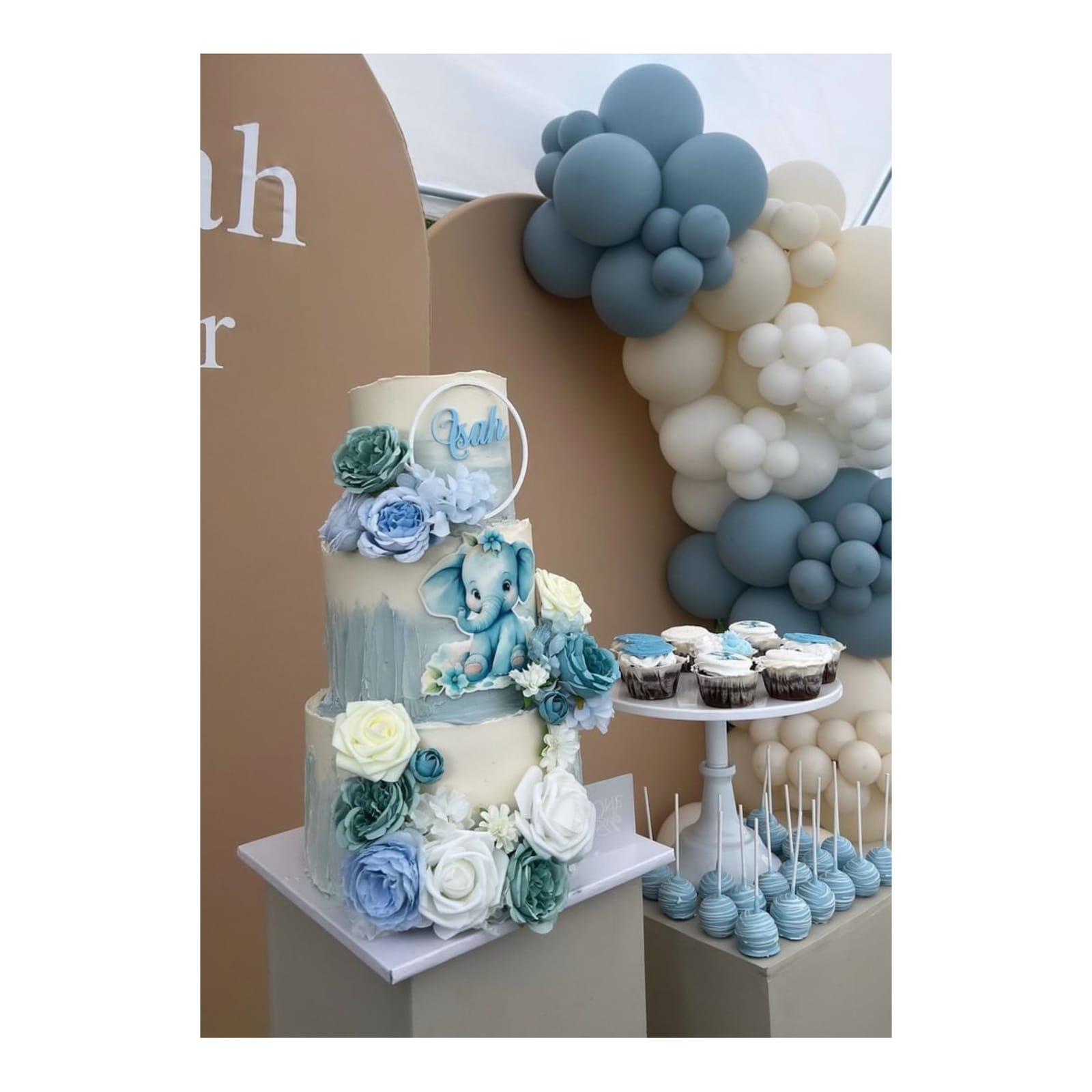 Dessertbord med blå elefanttårta, cupcakes, cakepops och ballongbåge till babyshower