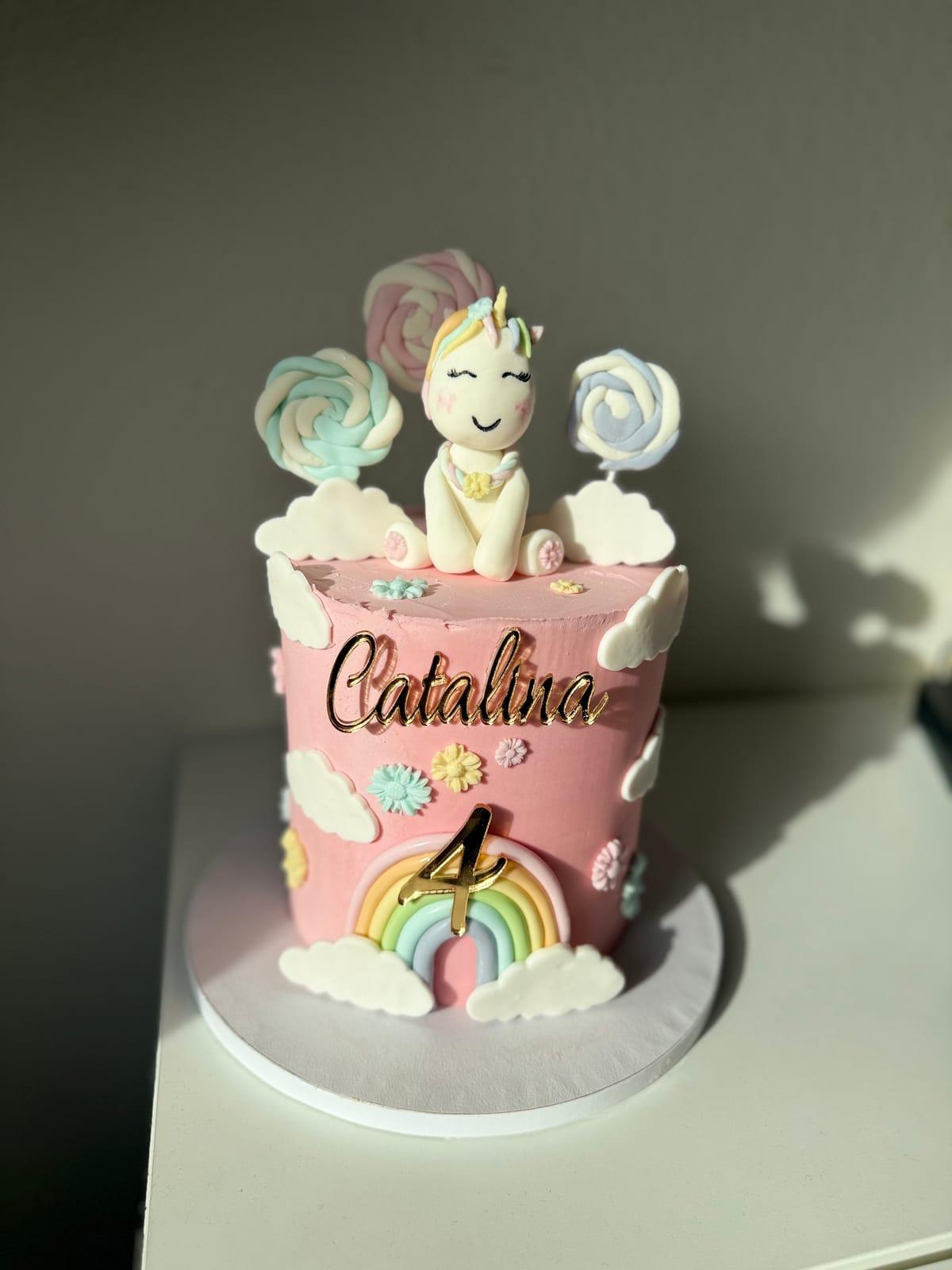 Rosa enhörningstårta med regnbåge och polkagrisar