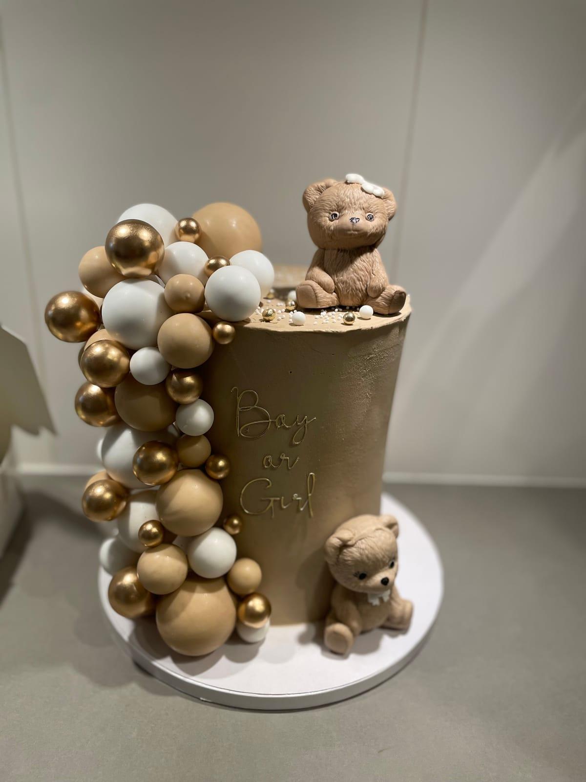 Gender reveal-tårta Boy or Girl med nallar och bollar i guld