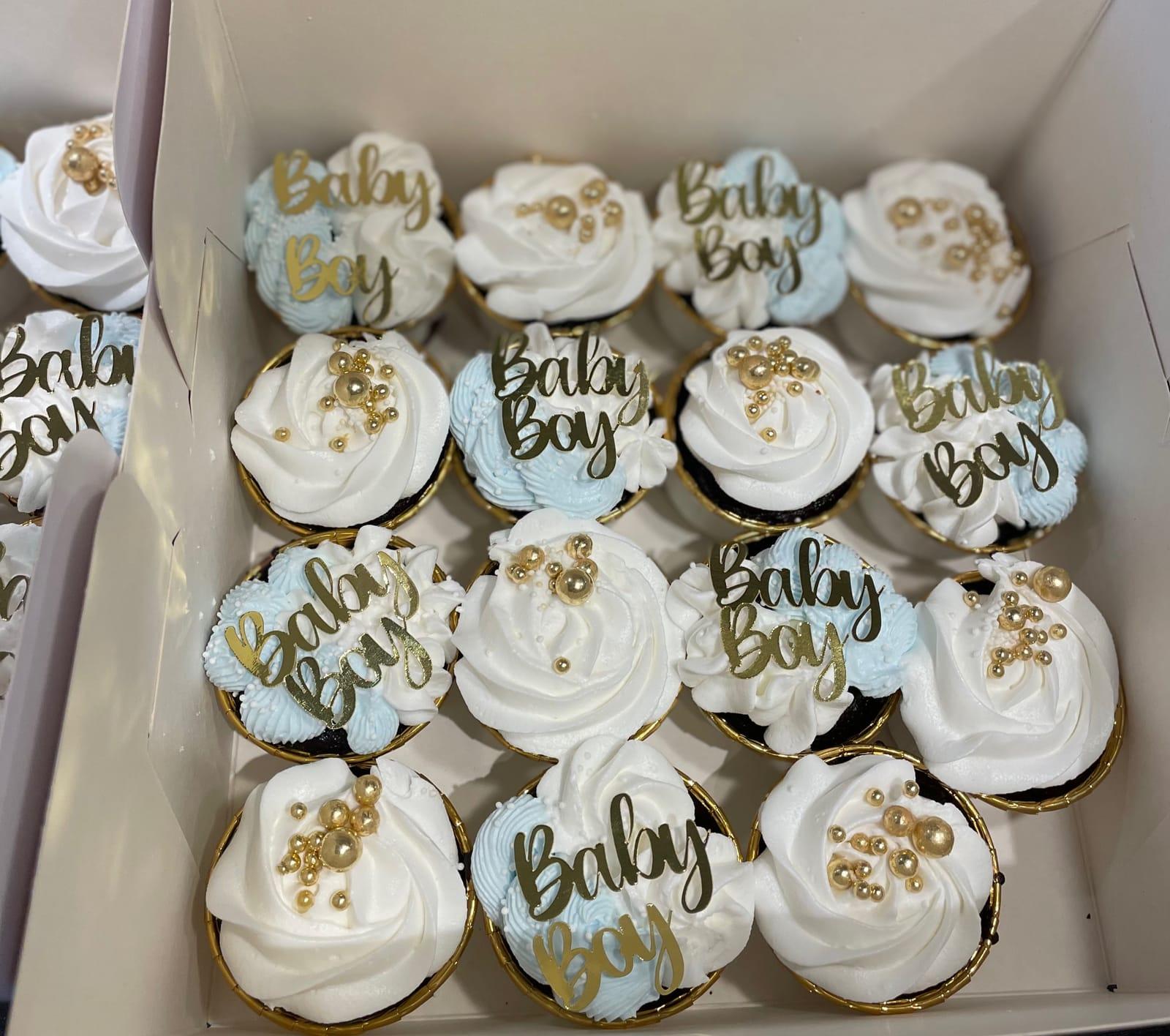 Baby Boy-cupcakes i vitt och blått med guldpärlor