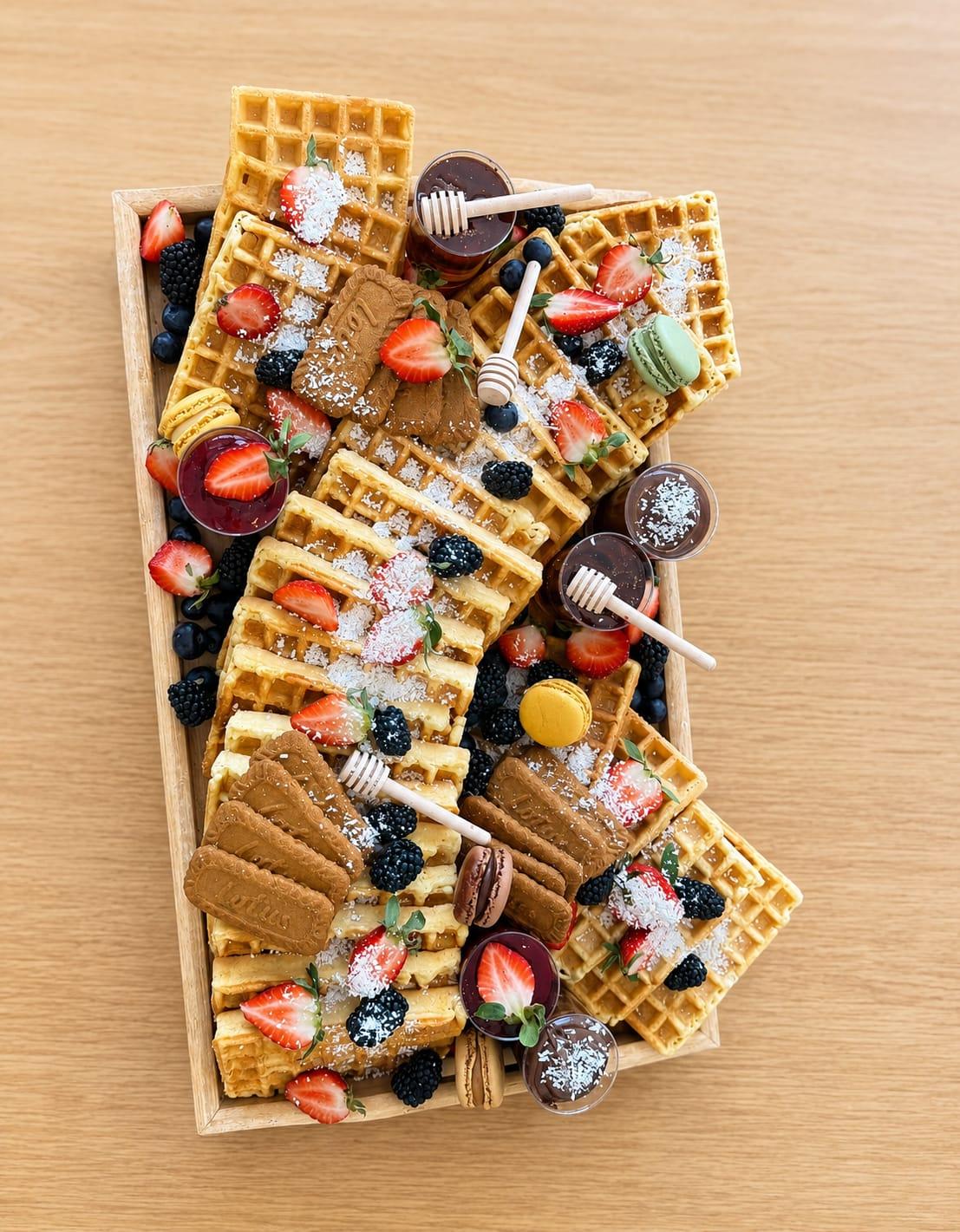 Våffelbricka med färska bär, honung, macarons och kakor